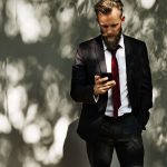 man met baard en mobiel